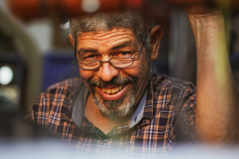 Homem de cabelos grisalhos e óculos, sorrindo